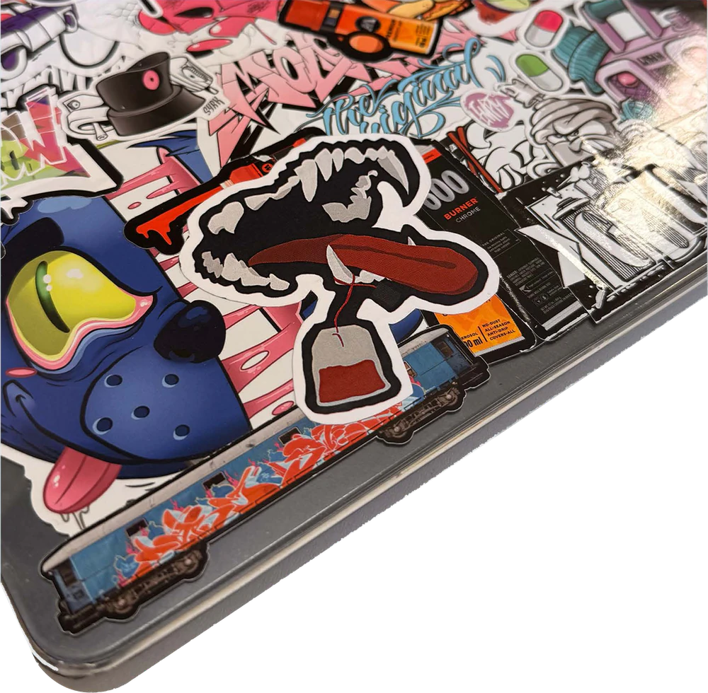 Laptop lid covered in stickers, with the Sip N' Snarl jaw and tea bag stickers applied.
